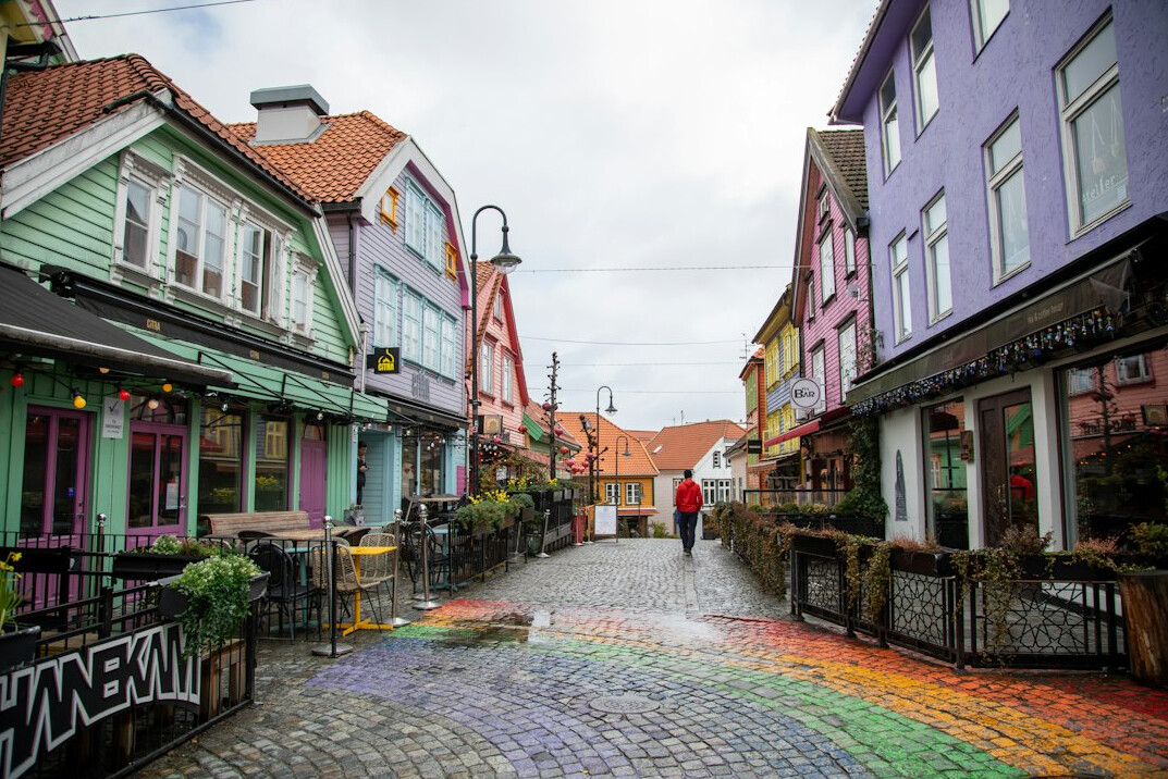 Old town street with colorful historic houses and cafe tables